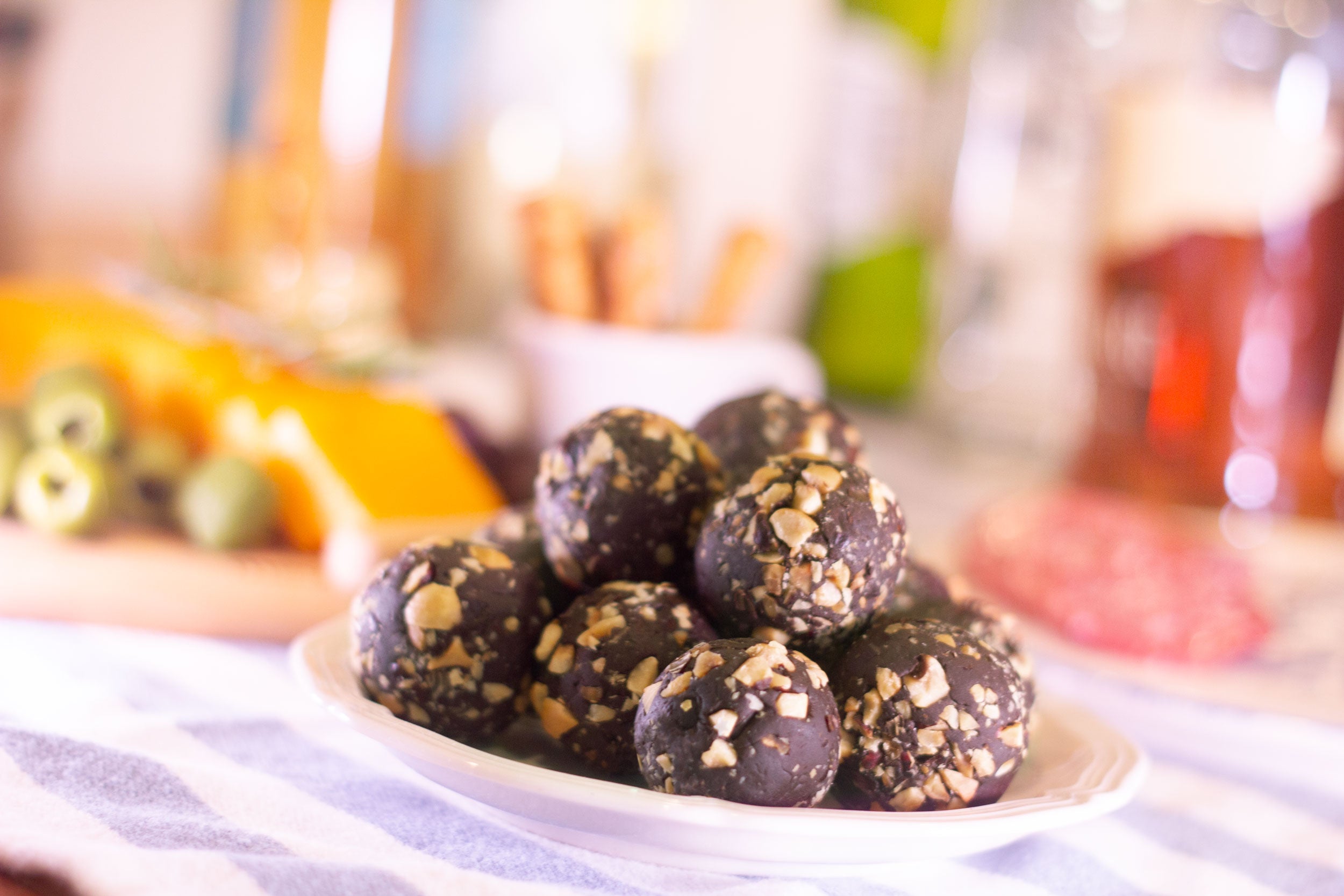 Decadent chocolate liqueur balls dessert in front of a charcuterie board at a party