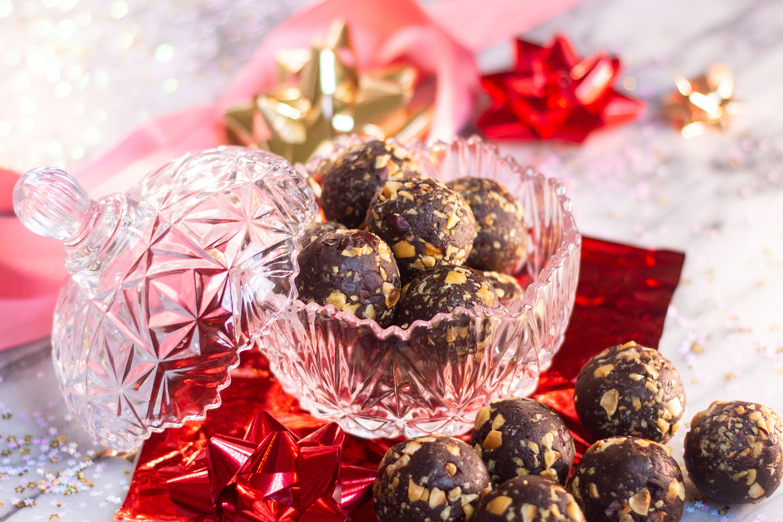Decadent chocolate liqueur balls dessert in a glass bowl with red ribbons